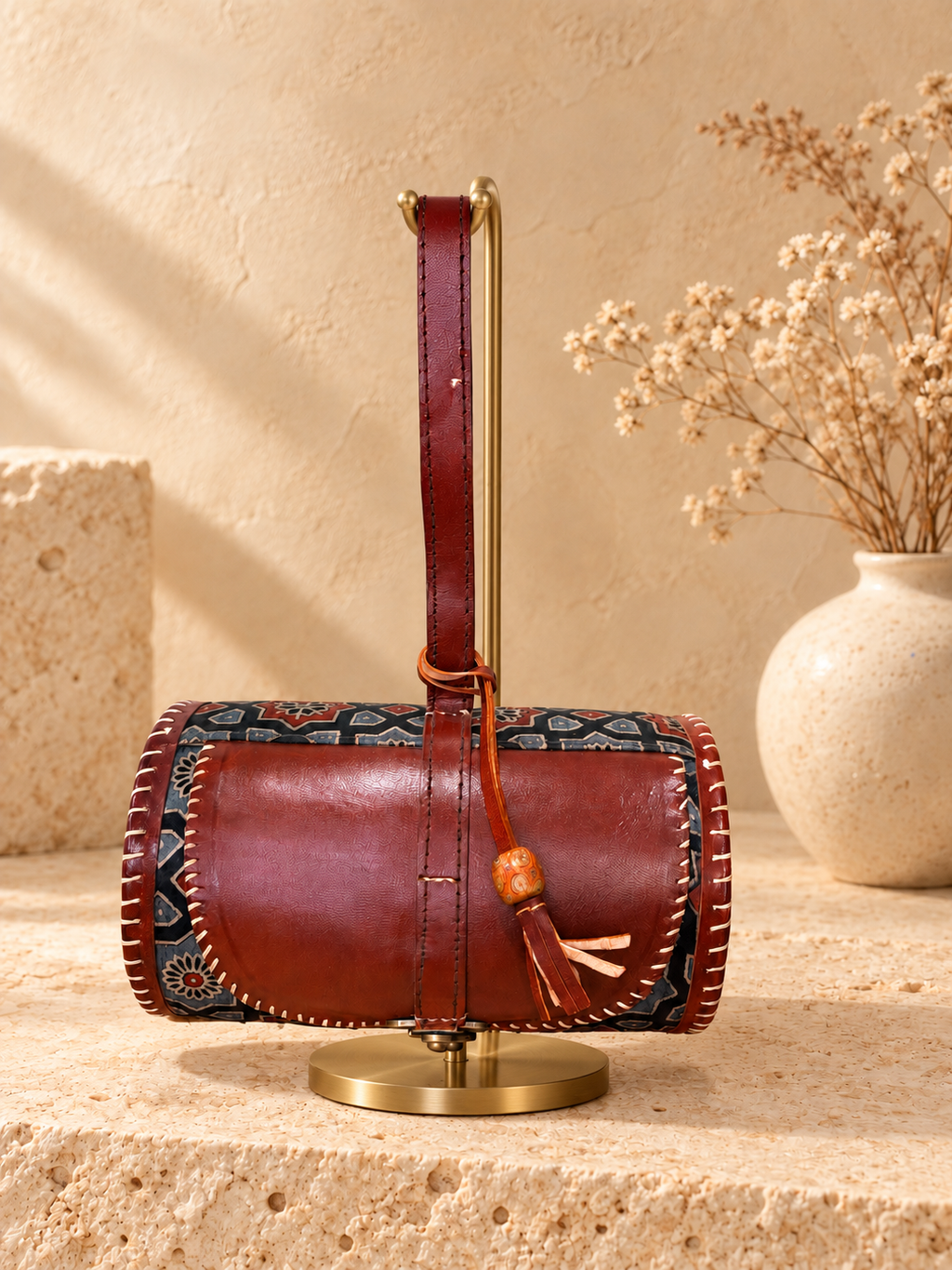 Traditional Dholak Handbag – Brown & Indigo on a gold display stand