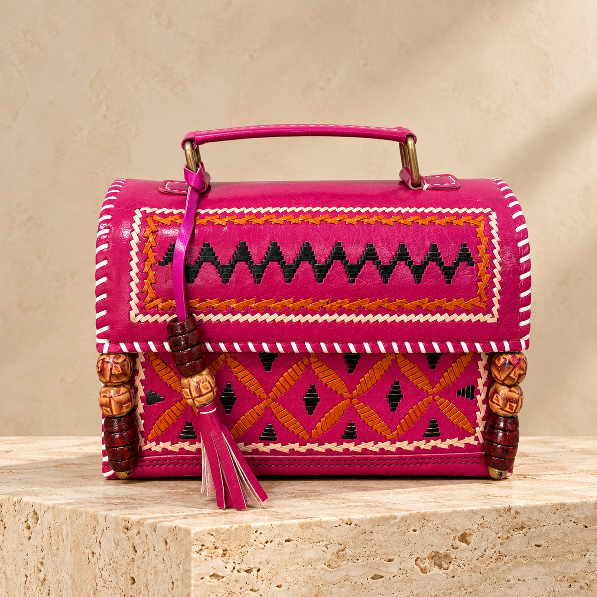 Fuchsia Kutch embroidery Hut Handbag on travertine pedestal