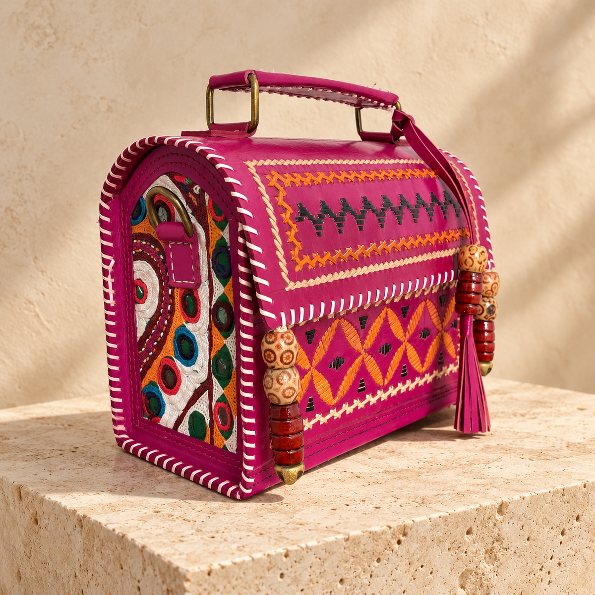 Side angle of Fuchsia Kutch Embroidery Hut Handbag showing embroidered side panel and sling attachment