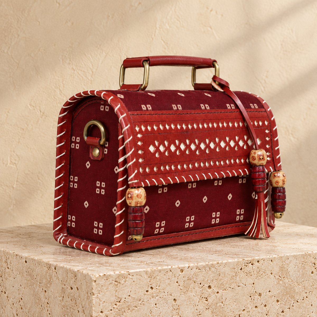 Side angle of Maroon Bandhej Hut Handbag showing patterned side and sling attachment
