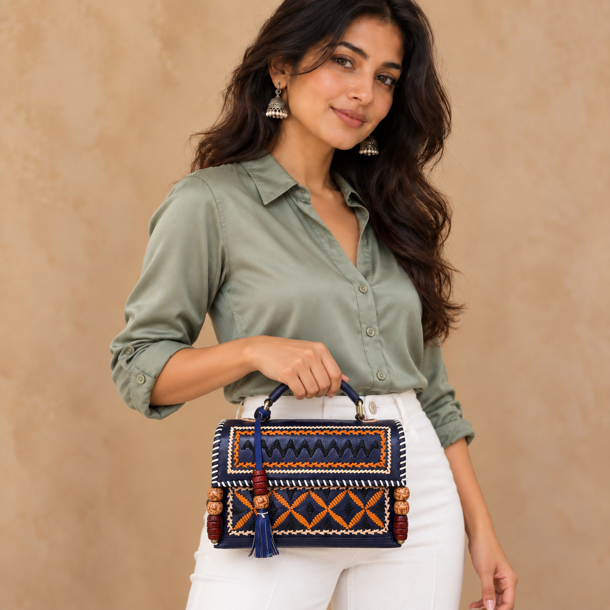 Navy Kutch Embroidery Hut Handbag held by model in white pants