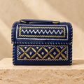 Navy metallic embroidery Hut Handbag on travertine pedestal