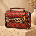 Hut Handbag in rust red – on a stone pedestal