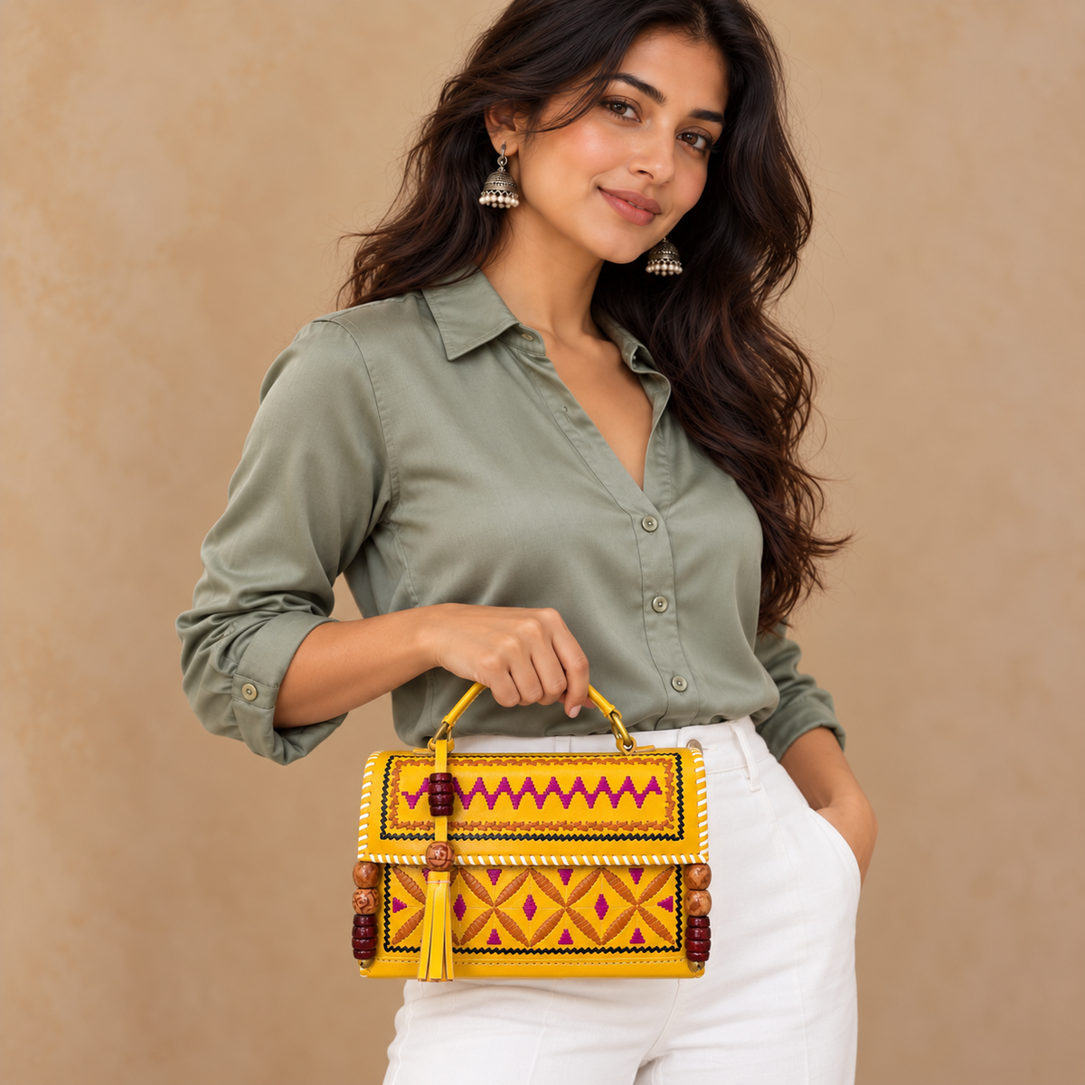Yellow Kutch Embroidery Hut Handbag held by model in white pants